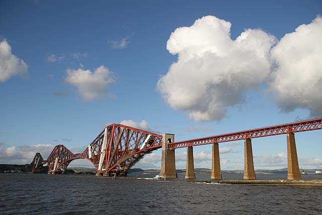 A diesel hauled train approaches Dalmeny station at the southern end of the Forth Rail Bridge