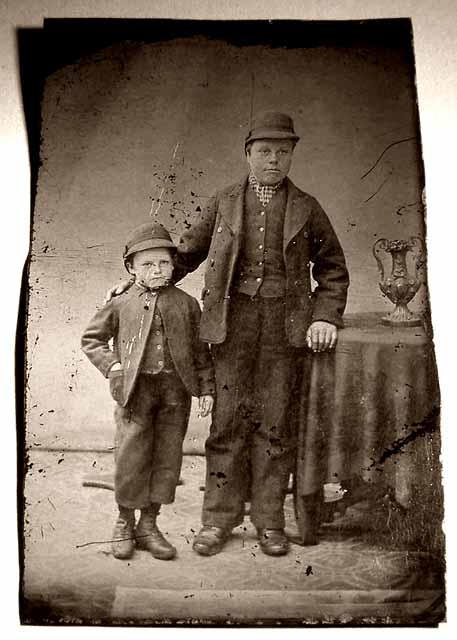 Unframed quarter-plate tintype photograph of a man, a boy and a trophy