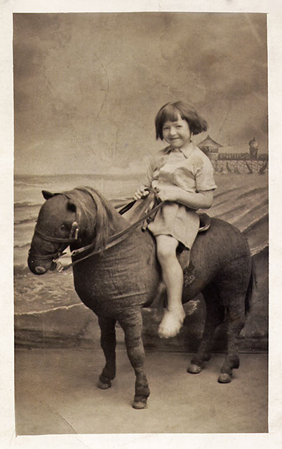 Photo from the Portobello studio of Robert McLelland - Postcard portrait of a girl on a stuffed donkey, around 1935