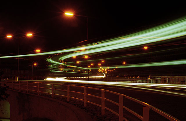 Roundabout at the junction of Calder road and Broomhouse Road  -  Close-up of traffic trails at night.  Photo taken late-1970s