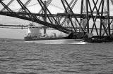 A Tanker heading out to Sea passes under the Forth Bridges as a train heading for Edinburgh crosses the Forth Rail Bridge