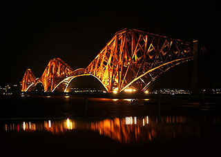 Talk to Edinburgh Photograhic Society  -  Edinburgh Themes  -  The Forth Bridges  -  Floodlit Rail Bridge and Cruise Boat beneath the bridge after having taken a party to view the Fireworks celebrate the 50th Anniversary of the Opening of the Forth Road Bridge