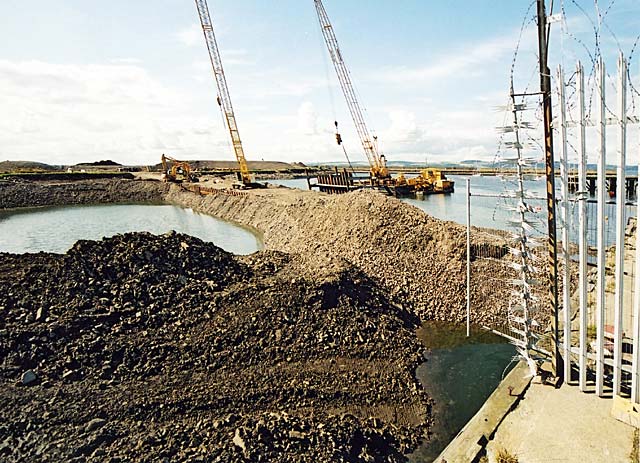 Reclaiming the land in Granton Western Harbour  -  looking to the north-west from Middle Pier towards pile driving in the harbour  -  July 2004