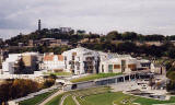 The Scottish Parliament Building  -  with Calton Hill and the former Royal High School in the background