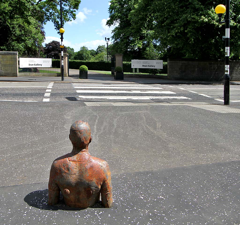 One of the live-size cast iron figures in the artwork '6 Times' by Antony Gormley.  The statues are sited, most in the Water of Leith, between the Scottish National Gallery of Modern Art and Leith Docks