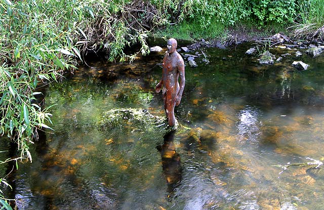 One of the live-size cast iron figures in the artwork '6 Times' by Antony Gormley.  The statues are sited, most in the Water of Leith, between the Scottish National Gallery of Modern Art and Leith Docks