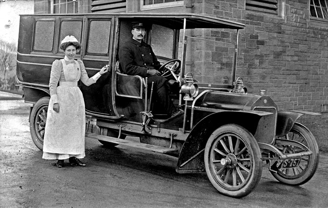 Photograph taken in 1907  -  Nurse Miss Mary Barrie Scott standing beside what is said to  be Einburgh's first motorised ambulance