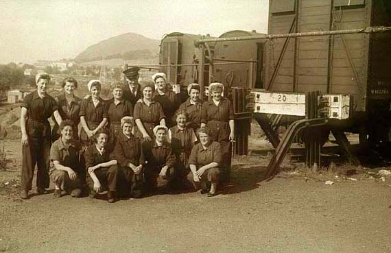 A group of 14 cleaners at Craigentinny, with Arthur's Seat in the background
