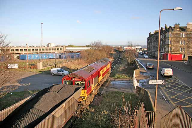 A coal train crosses the level crossing at Seafield, at the junction of Seafield Road and Marine Esplanade, after leaving Leith Docks