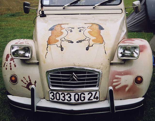 Zoom-out to see the front wing of a  Citroen 2CV in the grounds of Floors Castle,  Kelso, in the Scottish Borders  -  during the World 2CV Meeting held at Kelso, July 2005
