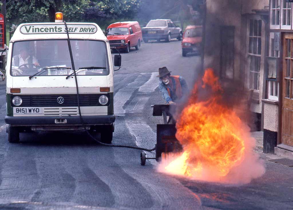 People at work around Britain  -  Burning tar off the road at Exford, Somerset, 1985