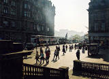View from the steps of Register House  -  Looking towards Edinburgh Castle with pedestrians at the East End of Princes Street in the foreground
