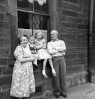 Forbes Wilson with his cousin, Lorraine, and his grandparents outside No 28 Thorntree Street, Leith  -  1960
